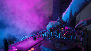 Dj playing music at sound mixer in night club